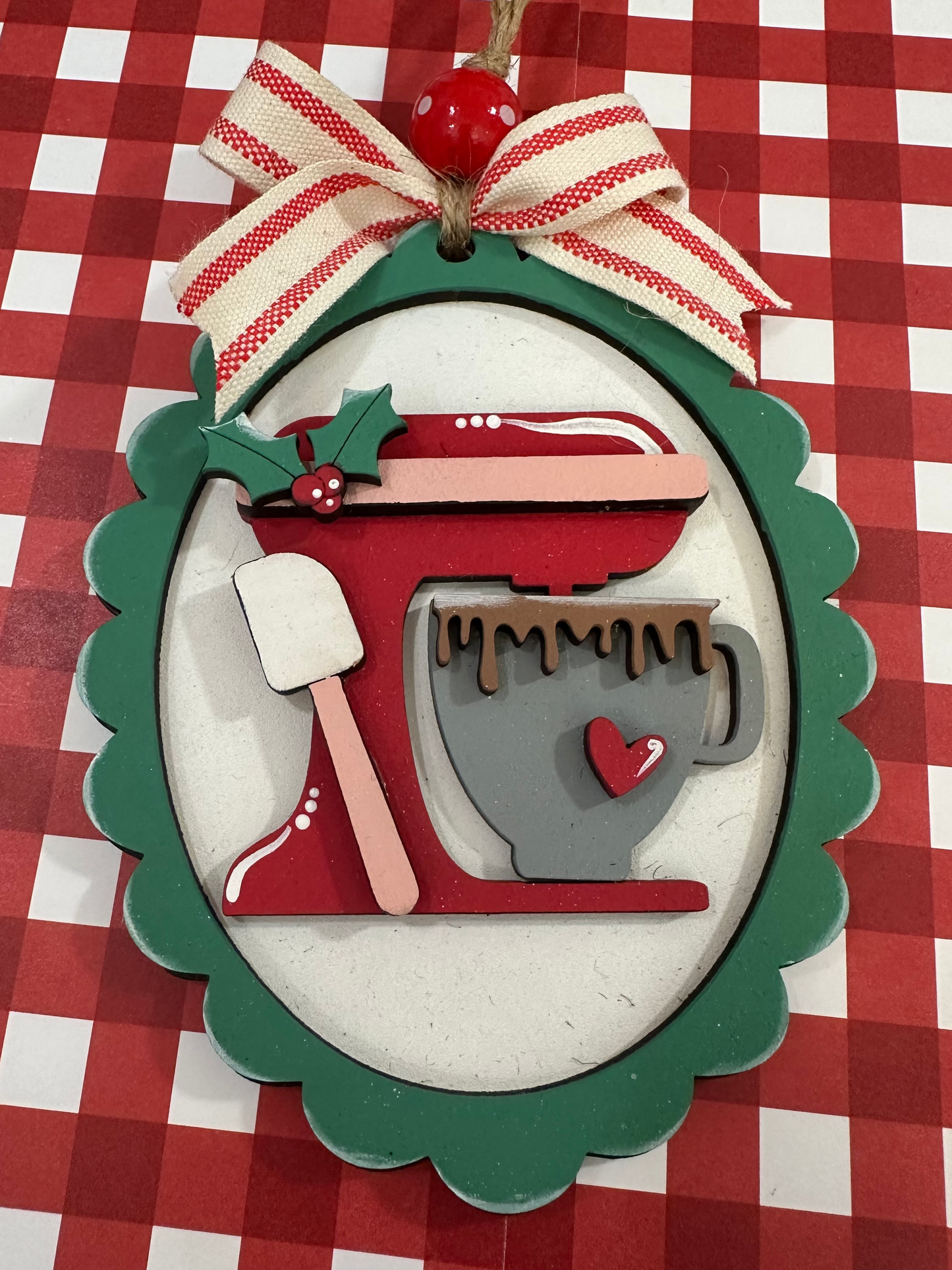 Decorative ornament with a red and green design on a red and white checkered background