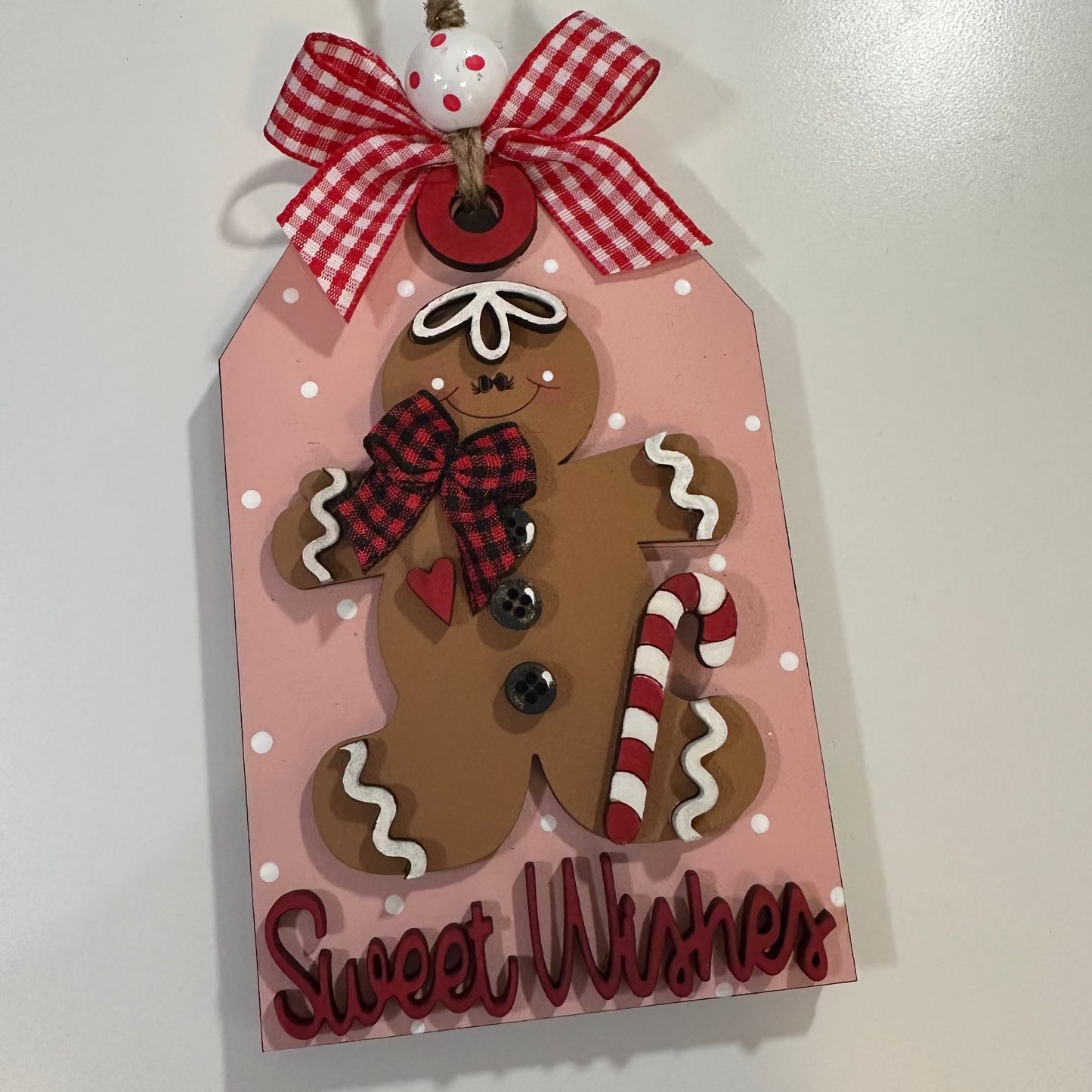 Decorative tag with a gingerbread man design and 'Sweet Wishes' text on a white background.